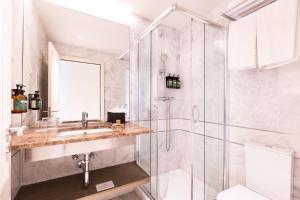 a bathroom with a shower and a sink and a toilet at Crowne Plaza - Caparica Lisbon in Costa da Caparica