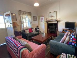 a living room with two couches and a table at Swallows Cottage, Margaret River in Witchcliffe