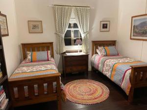 a bedroom with two beds and a window at Swallows Cottage, Margaret River in Witchcliffe