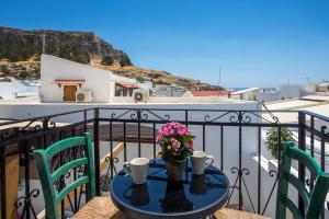 a table with flowers and cups on a balcony at Villa Sakura in Lindos