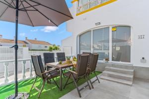 a patio with a table and chairs and an umbrella at Sweet Home in Gran Alacant