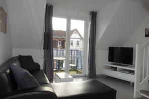 GraalにあるVilla Quisisana in der Kurstraße 2 OGのリビングルーム(ソファ、テレビ、窓付)