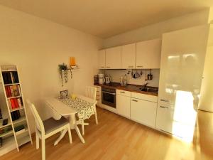 a kitchen with a table and a kitchen with white cabinets at Villa Quisisana in der Kurstraße 1 OG - BE in Graal