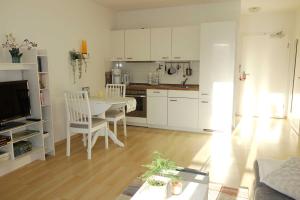 a kitchen with white cabinets and a table and chairs at Villa Quisisana in der Kurstraße 1 OG - BE in Graal