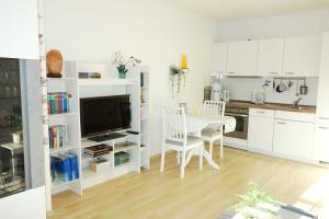 a kitchen with white cabinets and a table and chairs at Villa Quisisana in der Kurstraße 1 OG - BE in Graal