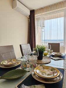 een eetkamer met een tafel met borden en glazen bij La casa di Nora in Varna +14 foto's