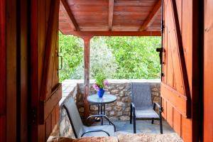 a patio with a table and chairs on a stone wall at Milea Traditional House-Private Garden Retreat in Miléa
