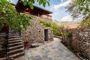 an external view of a stone house with a stone wall at Milea Traditional House-Private Garden Retreat in Miléa