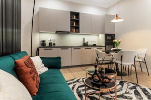 een woonkamer met een groene bank en een tafel bij Frida's Dream Suite in Boedapest