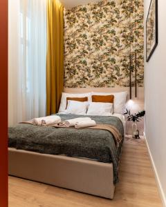 een slaapkamer met een bed met een bloemenmuur bij Frida's Dream Suite in Boedapest +10 foto's