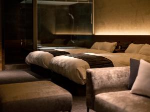 a hotel room with two beds and a couch at ROYAL CHESTER NAGASAKI hotel&retreat in Nagasaki