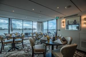 a restaurant with tables and chairs and a large window at VIVA RIVERSIDE Messe Düsseldorf in Düsseldorf +14 photos