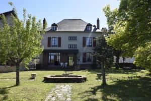 a large white house with trees in front of it at Maison Mère in Arnac-Pompadour