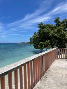 a view of the ocean from a wooden fence at 4S Transient Home in Oslob