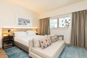 a hotel room with a bed and a couch at Crowne Plaza - Caparica Lisbon in Costa da Caparica