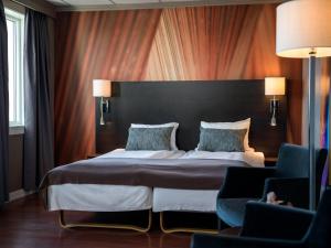 a bedroom with a large bed and two chairs at Quality Hotel Grand Royal in Narvik