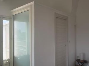 a white room with a door and a window at La Corte di Zia Lucia - vicino Ospedale Panico - Cammino del Salento in Tricase +17 photos