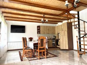 a kitchen with wooden ceilings and a table and chairs at Casa de vacanță in Orlat