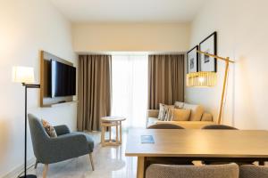 a living room with a couch and a table at Crowne Plaza - Caparica Lisbon in Costa da Caparica