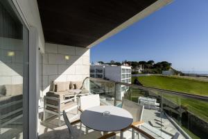 a patio with a table and chairs on a balcony at Crowne Plaza - Caparica Lisbon in Costa da Caparica
