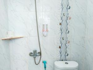 a bathroom with a shower with a toilet in it at Themas Guest House in Jakarta
