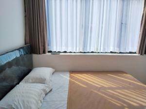 a room with a bed in front of a window at Themas Guest House in Jakarta