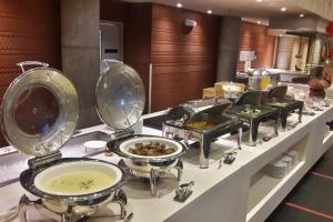 een buffet met etensbakken bij Hilton Garden Inn Bali Ngurah Rai Airport in Kuta