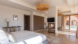 a bedroom with a bed and a tv and a room with at Luxury Villa Rêve D'ahlam à MARRAKECH in Oulad Boudene