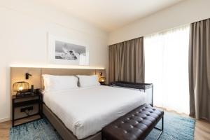 a hotel room with a bed and a large window at Crowne Plaza - Caparica Lisbon in Costa da Caparica