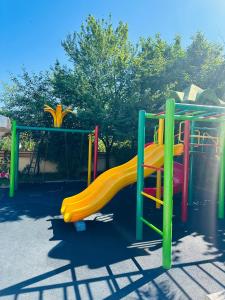 a playground with a yellow slide at a park at Hotel Buta in Batumi