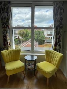two chairs and a table in front of a window at Beach Lodge in Bournemouth