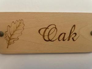a wooden sign with the word oak and a leaf at Beach Lodge in Bournemouth