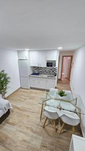 a kitchen with a glass table and chairs in a room at Apartamento Los Mosaicos in Santiponce