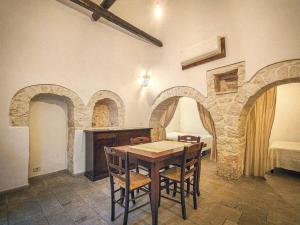 a dining room with a table and chairs and a bed at Trullo Originale di Alberobello in Alberobello +11 photos