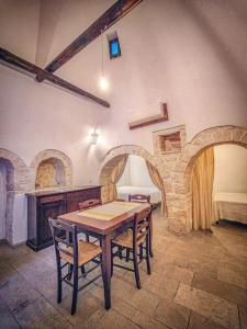 a room with a table and chairs and a bed at Trullo Originale di Alberobello in Alberobello