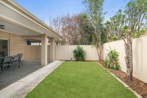 a backyard with a fence and a lawn at LUX Henley Beach - 4BD 3 5BA in Henley Beach