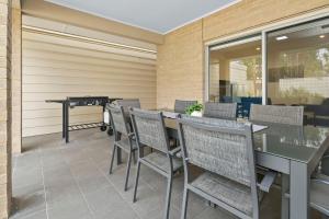 a patio with a ping pong table and chairs at LUX Henley Beach - 4BD 3 5BA in Henley Beach