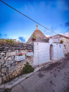 an old stone building with a stone wall at Trullo Originale di Alberobello in Alberobello