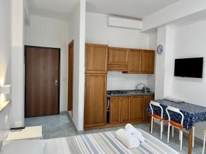 una cucina con mobili in legno e un tavolo con sedie di Appartamenti Antonio a Tropea Altre 34 foto