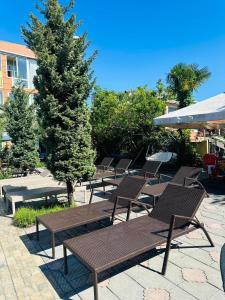 a group of wooden benches sitting on a patio at Hotel Buta in Batumi