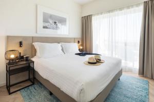 a bedroom with a large bed with a hat on it at Crowne Plaza - Caparica Lisbon in Costa da Caparica
