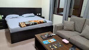 a bedroom with a bed and a couch and a coffee table at Room center in Muscat