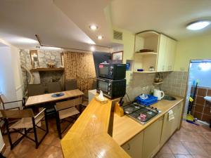 a small kitchen with a table and a stove in it at Sailor apartments in Pag +14 photos
