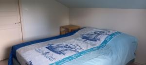 a bed with a blue and white blanket on it at l'Oulibo in Villeneuve-les-Corbières