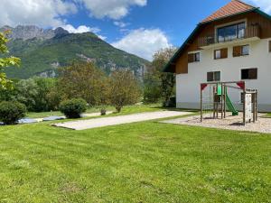 a playground in front of a building with a mountain at LE NID DU BIRDIE, Giez, Proche du lac d’Annecy in Giez