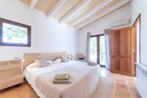 a white bedroom with a large bed and a window at S'hort des Frares in La Sorda +25 photos