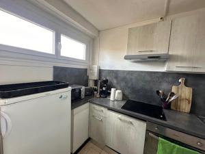 a kitchen with white cabinets and a counter top at Duplex Valras face mer in Valras-Plage