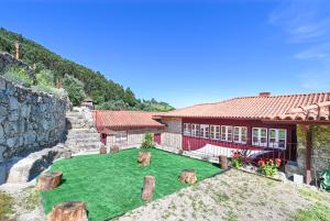 a house with a green yard with cows in front of it at Quinta Rolim do Bouro By Sé Apartamentos in Roucio