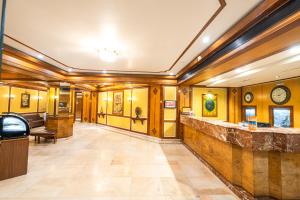 a lobby with wood paneled walls and a stone counter at Hotel Mayura in Raipur