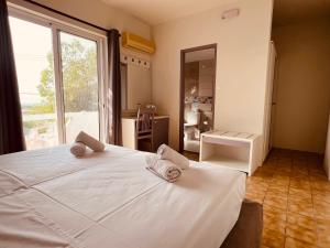 a bedroom with a large white bed and a large window at Maistrali Hotel & Restaurant in Kalavárda